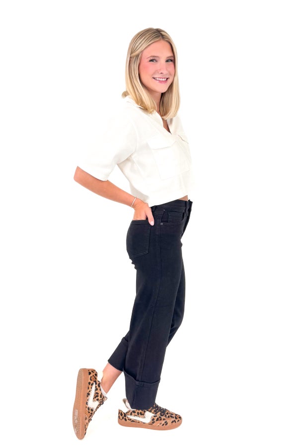 Woman wearing a white blouse and black pants on a white background