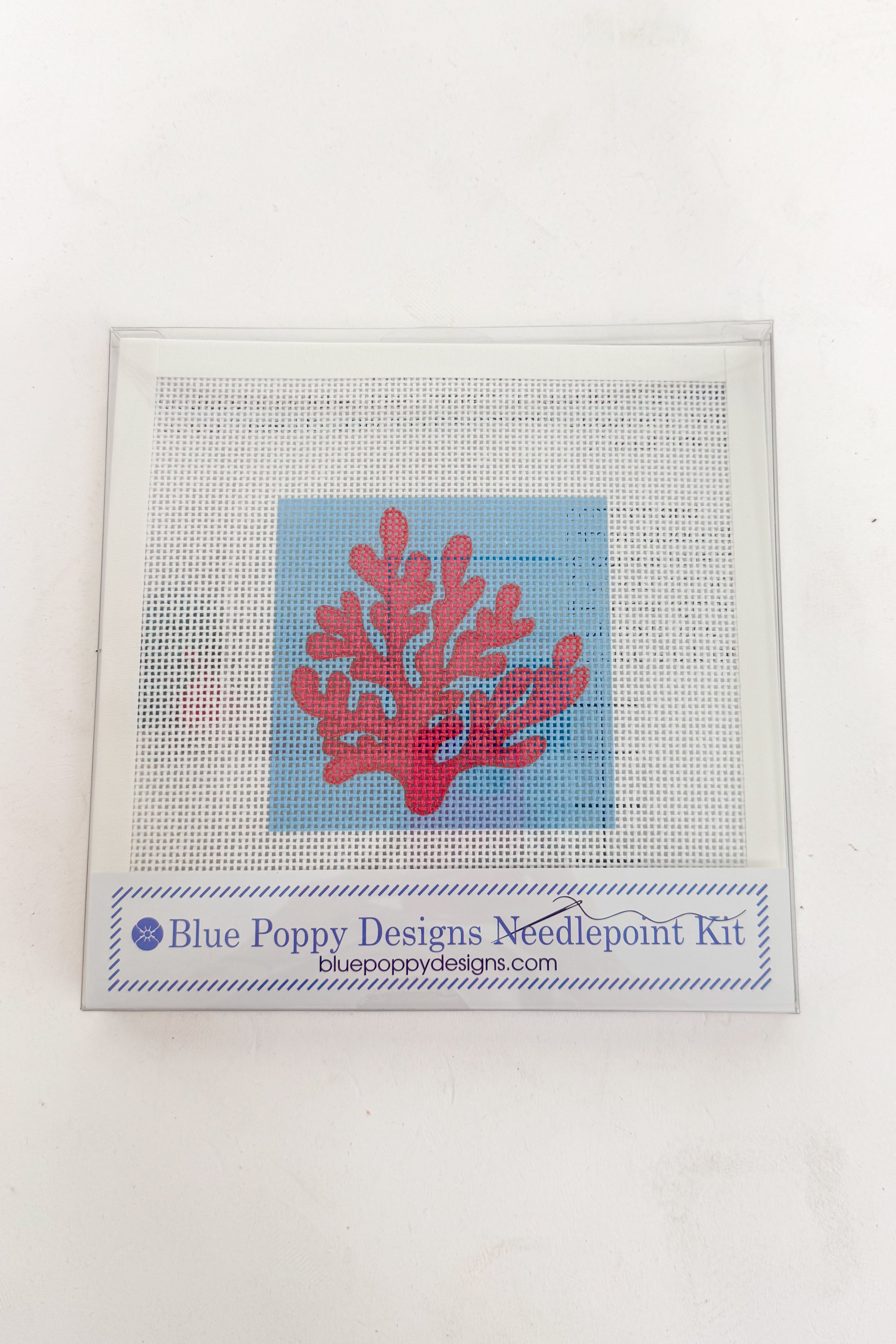 Needlepoint kit with red coral design on a white background