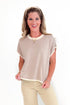 Woman wearing a beige top and pants on a white background