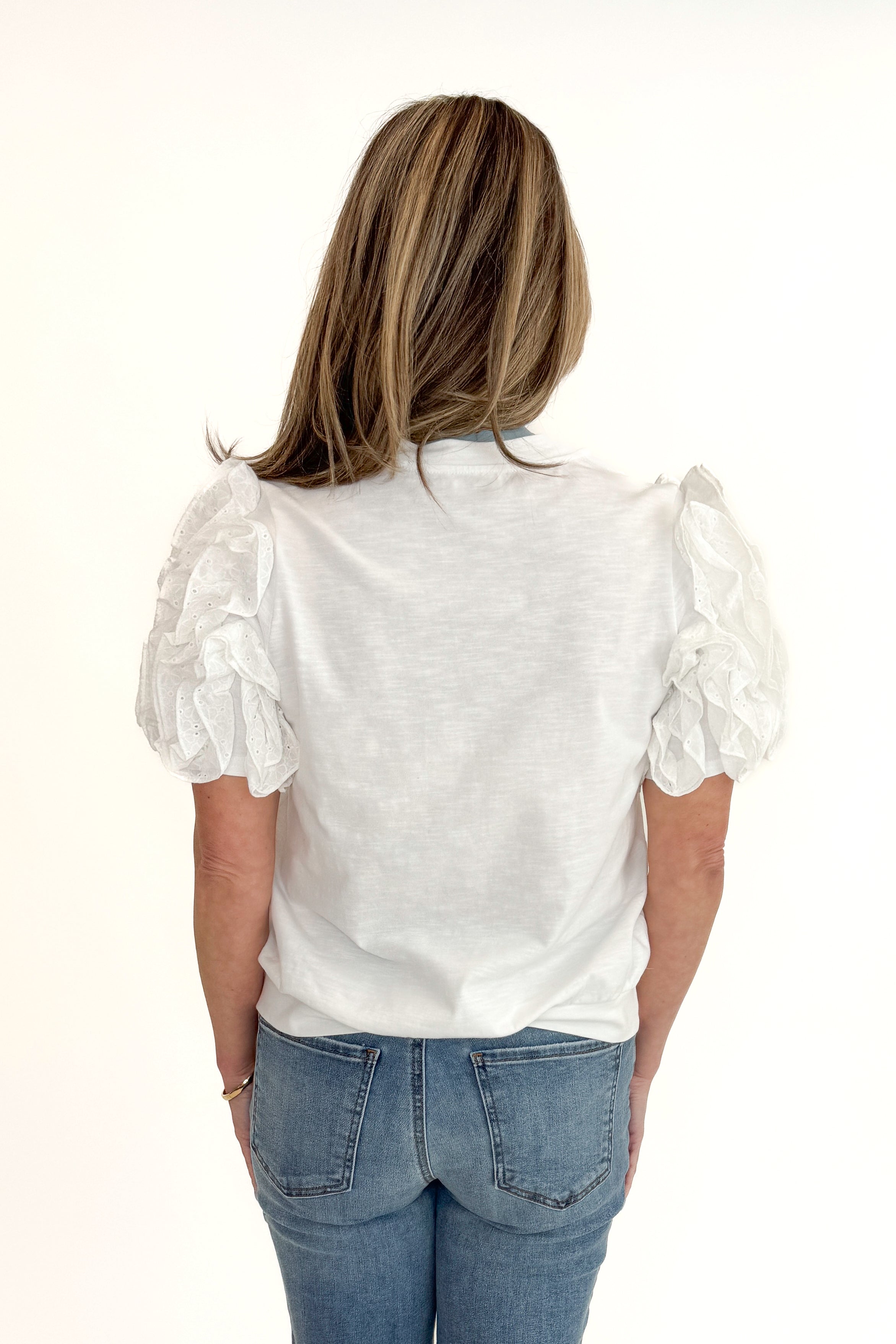 Back view of woman wearing White Ruffle Sleeve Detail Top by Fate with jeans against white studio background.