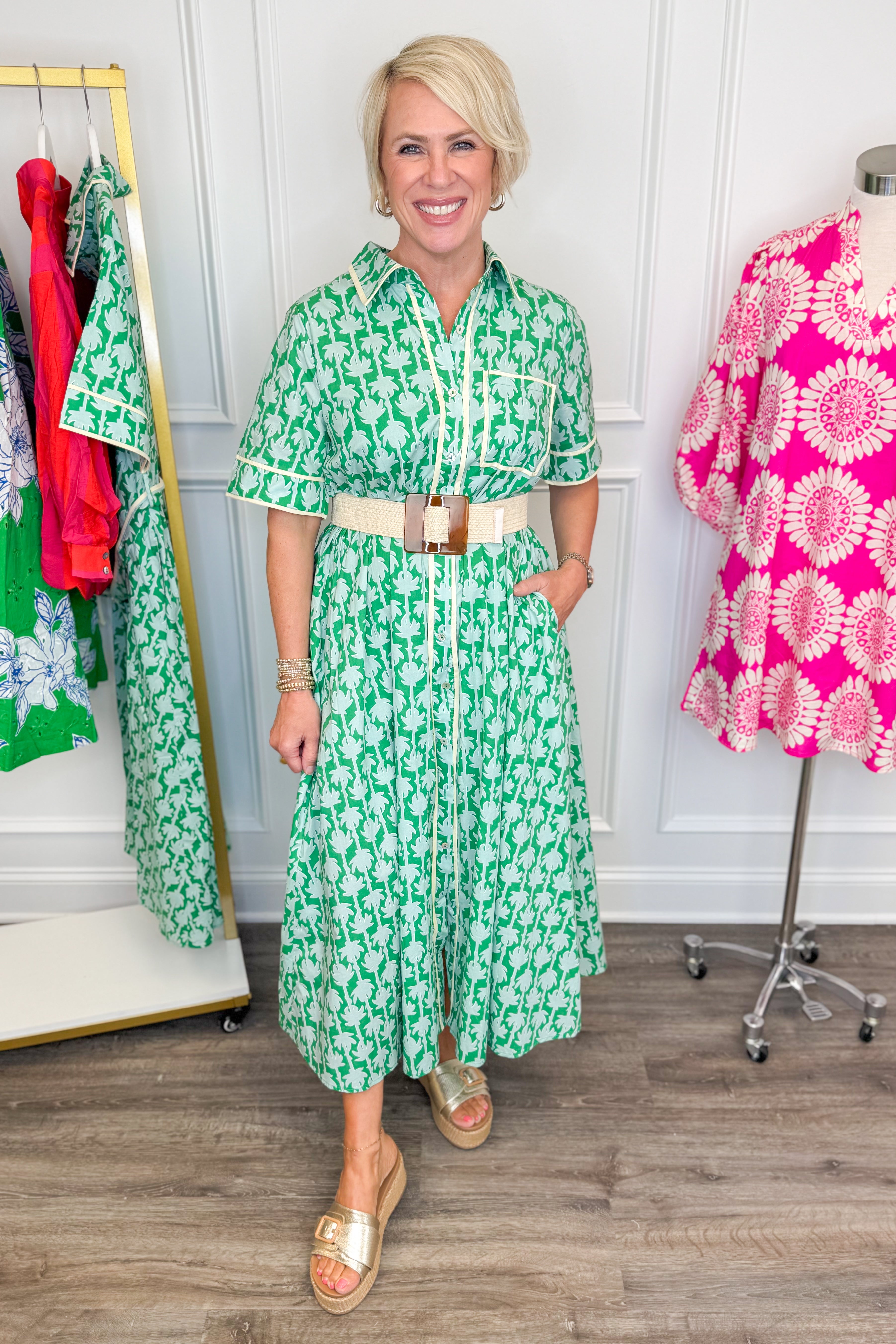 woman wearing green printed button down midi dress with tan stretch belt featuring a brown square buckle on a white background
