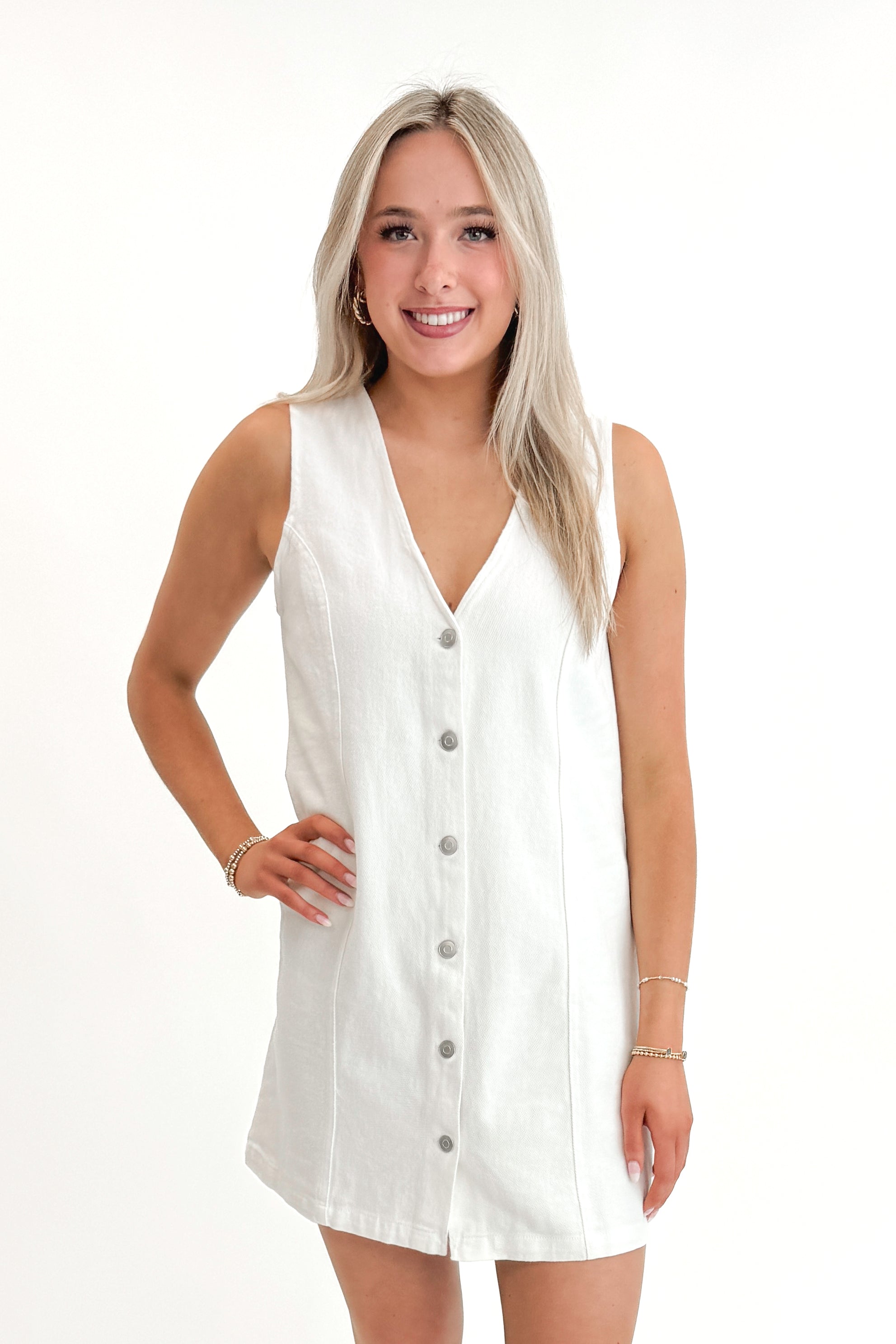 Front view of woman wearing White Denim Button Up Dress against white studio background.