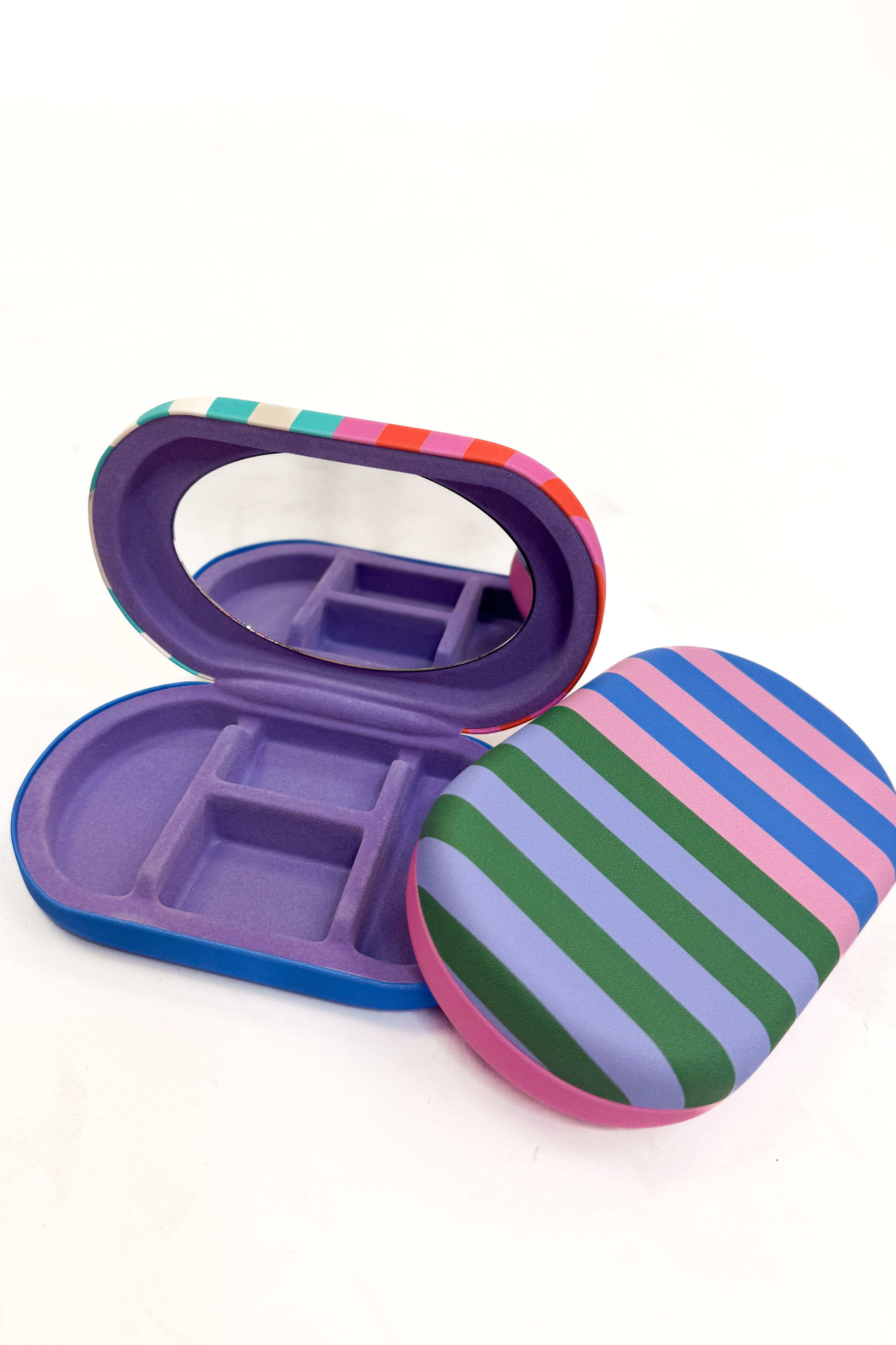 Colorful striped jewelry case with mirror on a white background