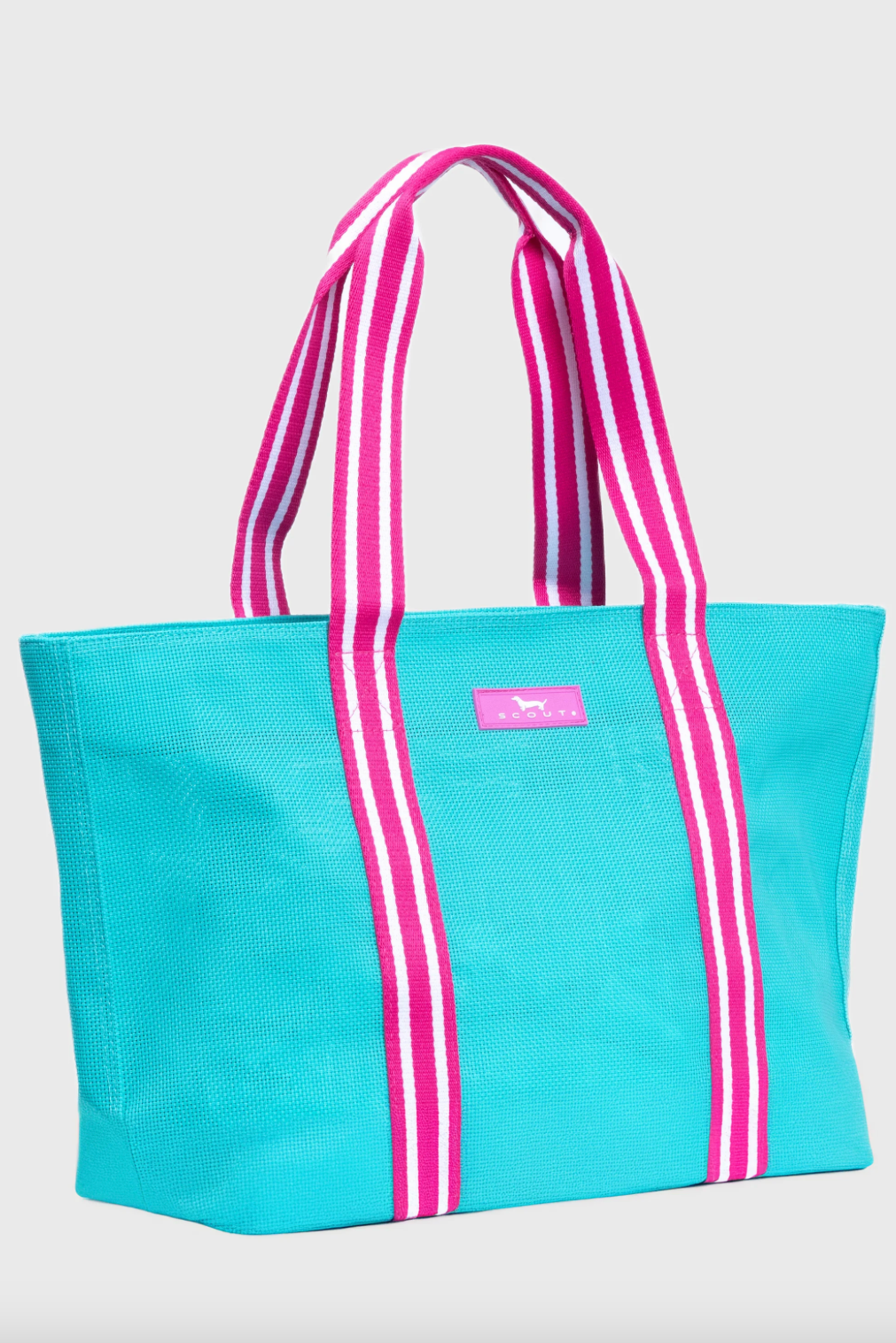 Blue tote bag with pink and white striped handles on a light gray background
