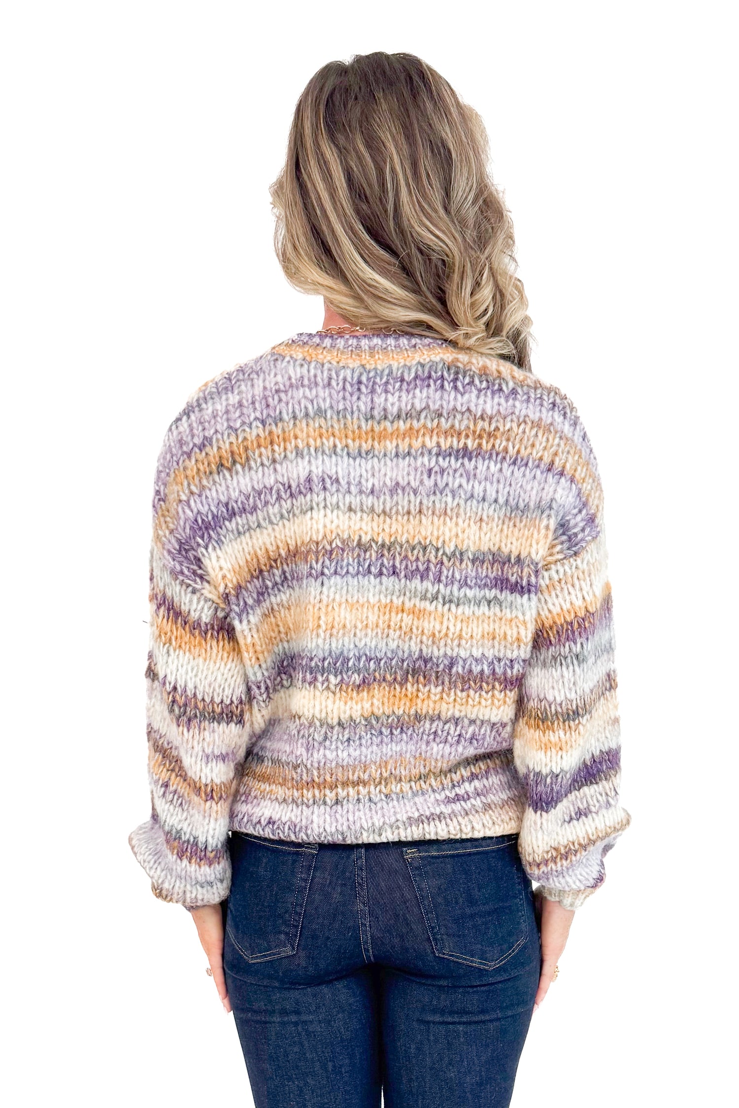 Back view of woman wearing Purple & Multi Striped Knit Sweater and jeans with white studio background.
