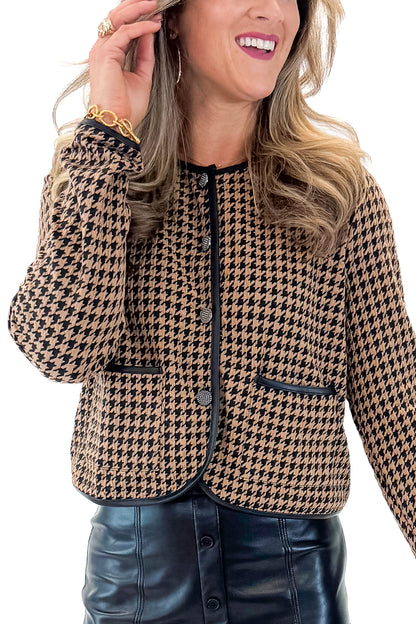 Front detail view of woman wearing Black &amp; Brown Houndstooth Jacket with black faux leather skirt against white studio background.