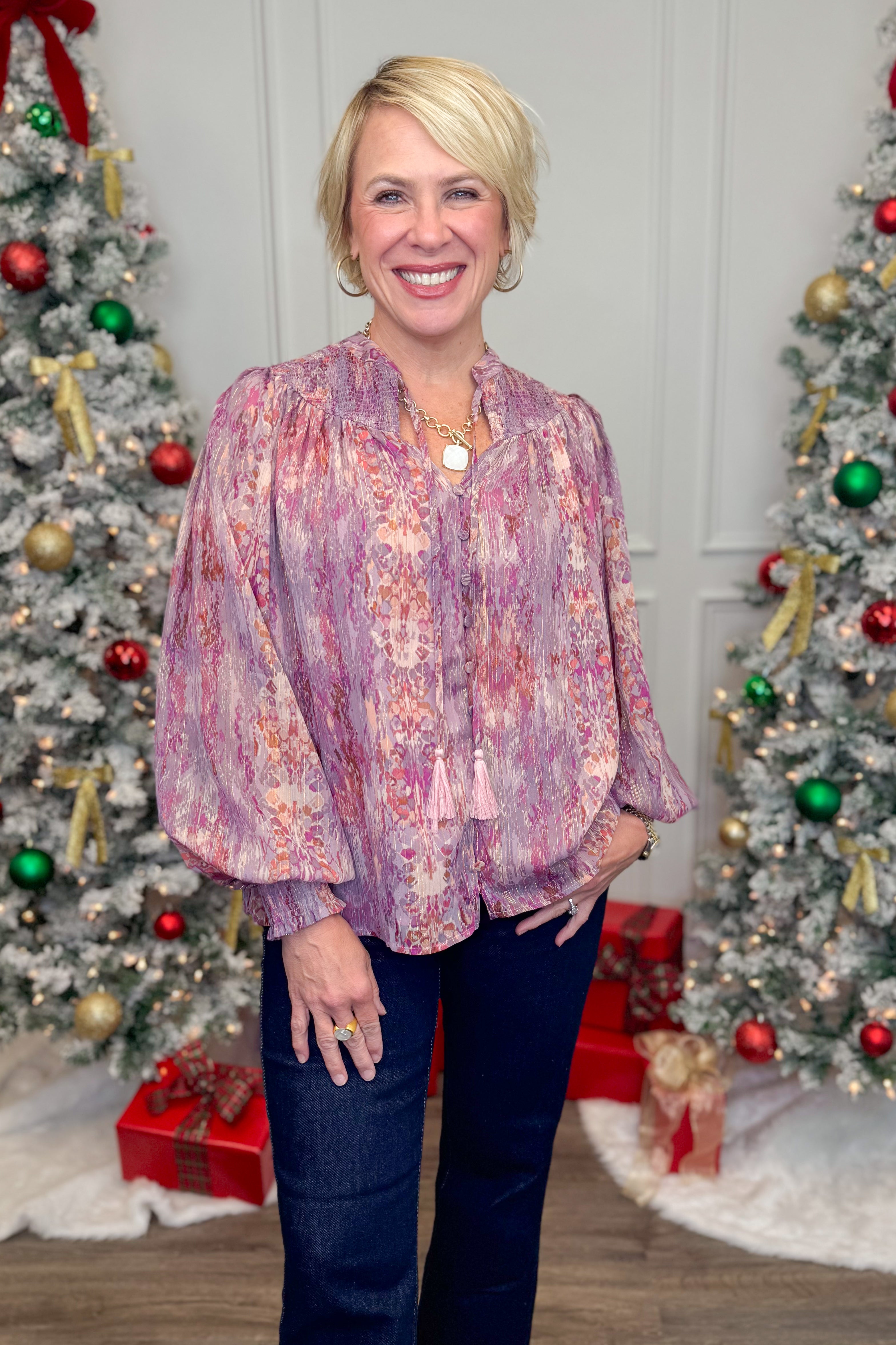 woman wearing a multi print long sleeve top in a christmas setting
