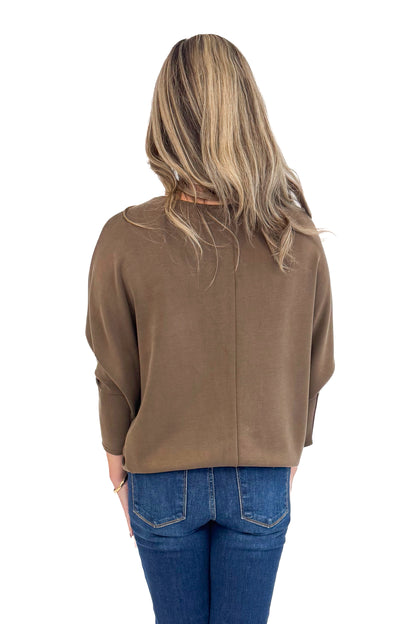 Woman wearing For Keeps Brown Boatneck Dolman Sleeve Top - back view showing elegant boatneck and relaxed dolman sleeves