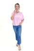 Front view of woman wearing Light Pink Dolman Sleeve Top with jeans against white studio background.