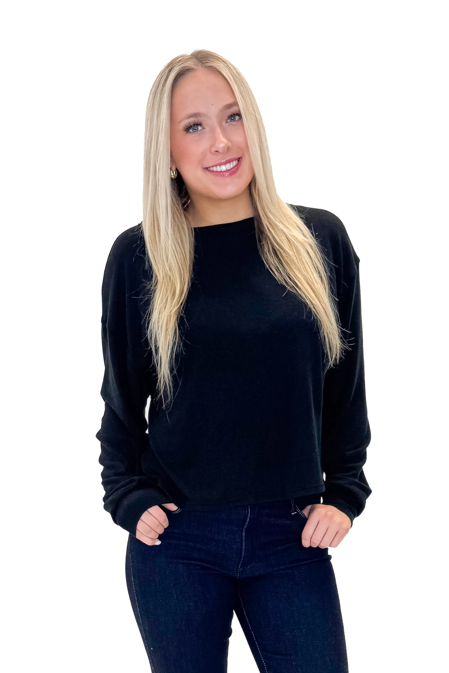 Front view of woman wearing Black Open Back Top with jeans against white studio background.