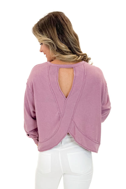 Back view of woman wearing Mauve Open Back Top with jeans against white studio background.