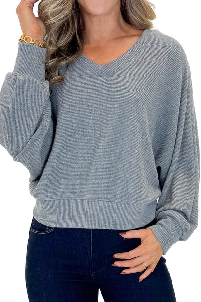 Front detail view of woman wearing Heather Grey Ribbed V-neck Banded Top with jeans against white studio background.