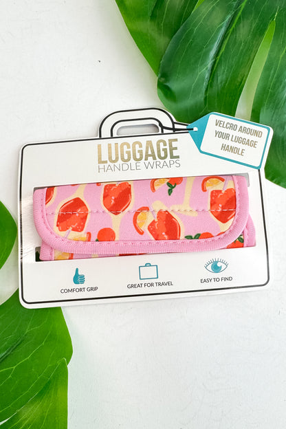 Luggage handle wrap with pink floral design on a white background