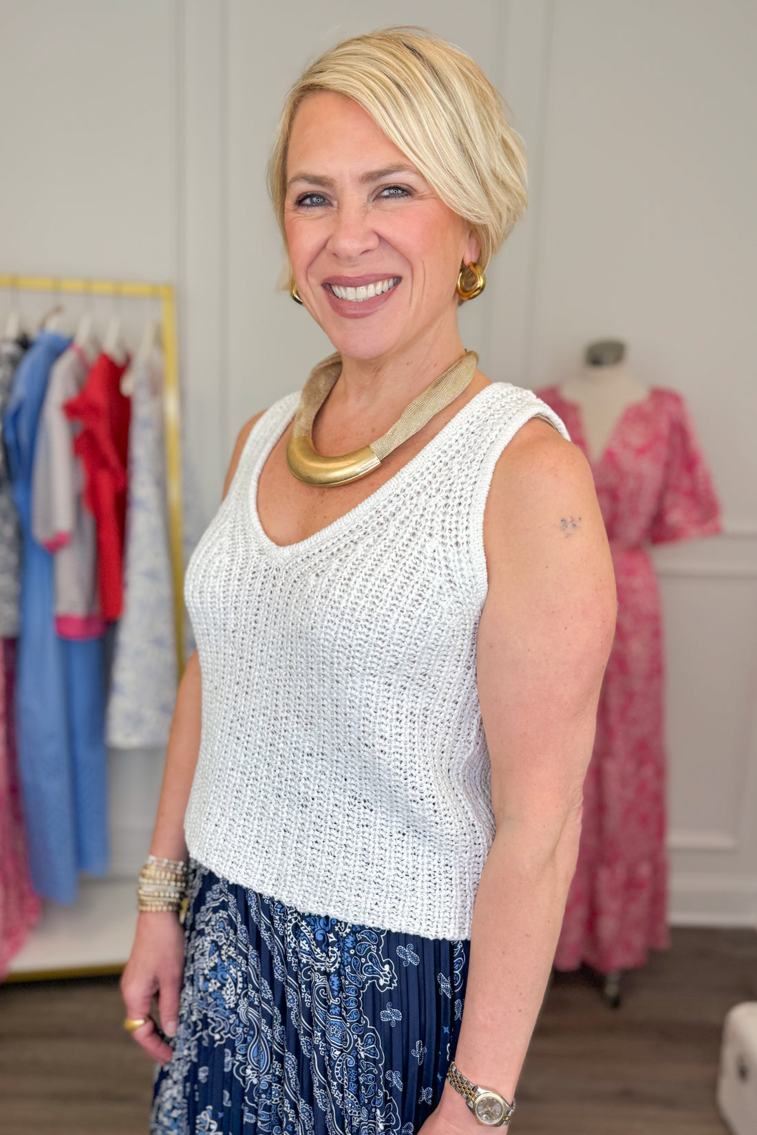 Side view of woman wearing White V-Neck Knitted Tank by Skies Are Blue with skirt.