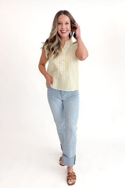 Front view of woman wearing Yellow Striped Flutter Sleeve Top with jeans against white studio background.