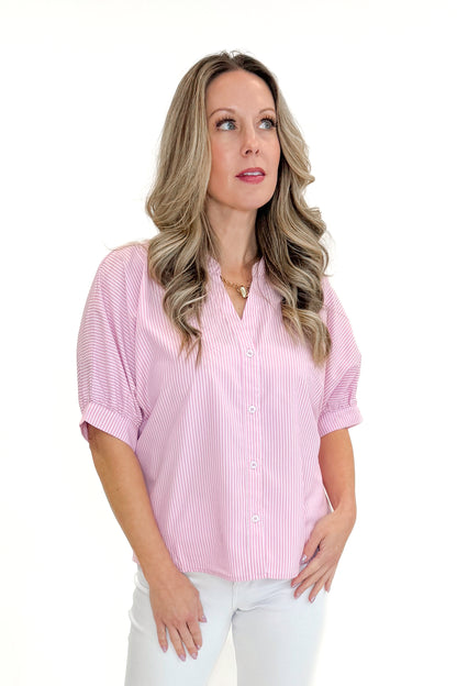 Front view of woman wearing Pink Striped V-Neck Button Up Top with jeans against white studio background.