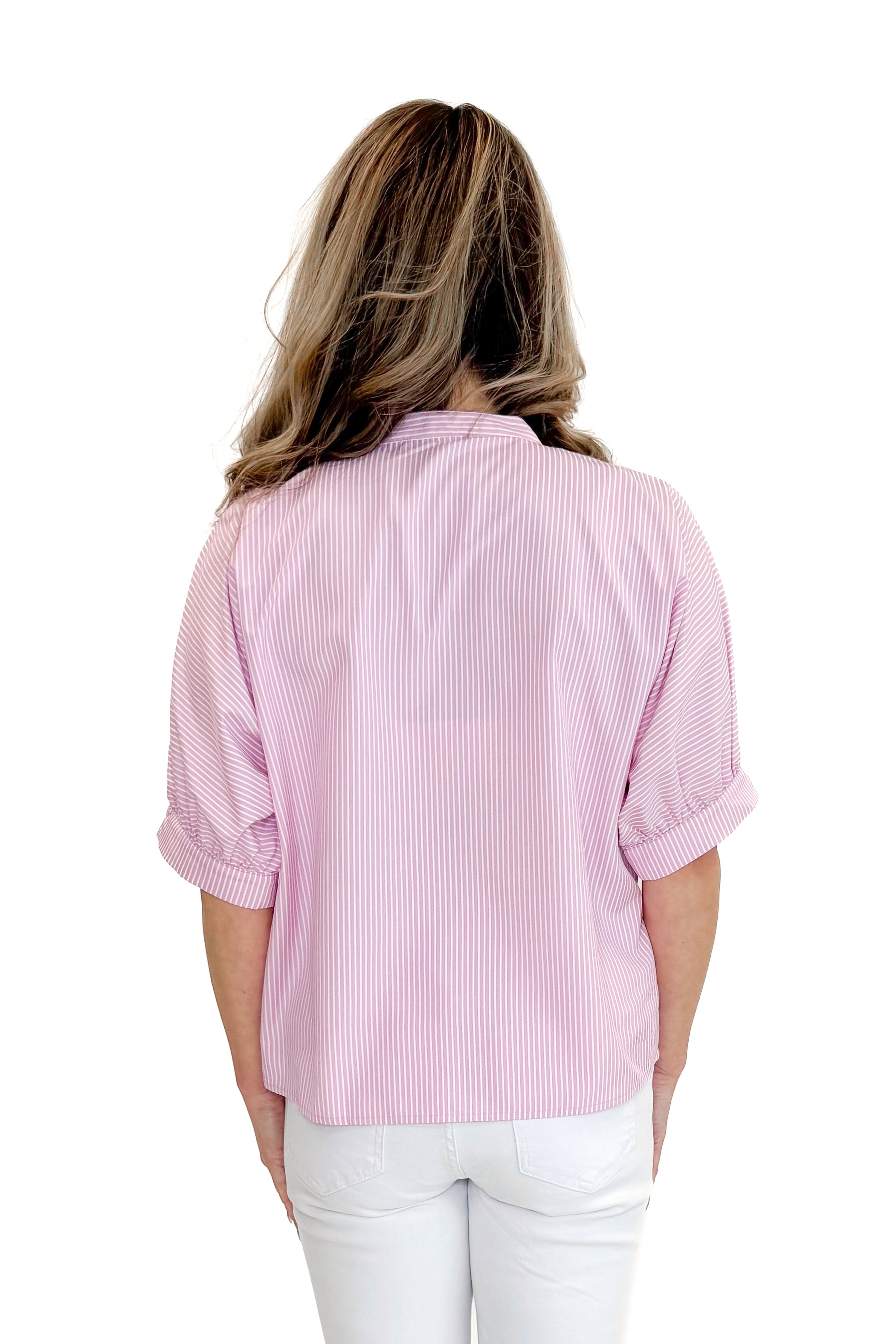 Back view of woman wearing Pink Striped V-Neck Button Up Top with jeans against white studio background.