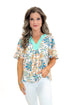 Front view of woman wearing Mint & Multi Tropical Printed Top with jeans against white studio background.