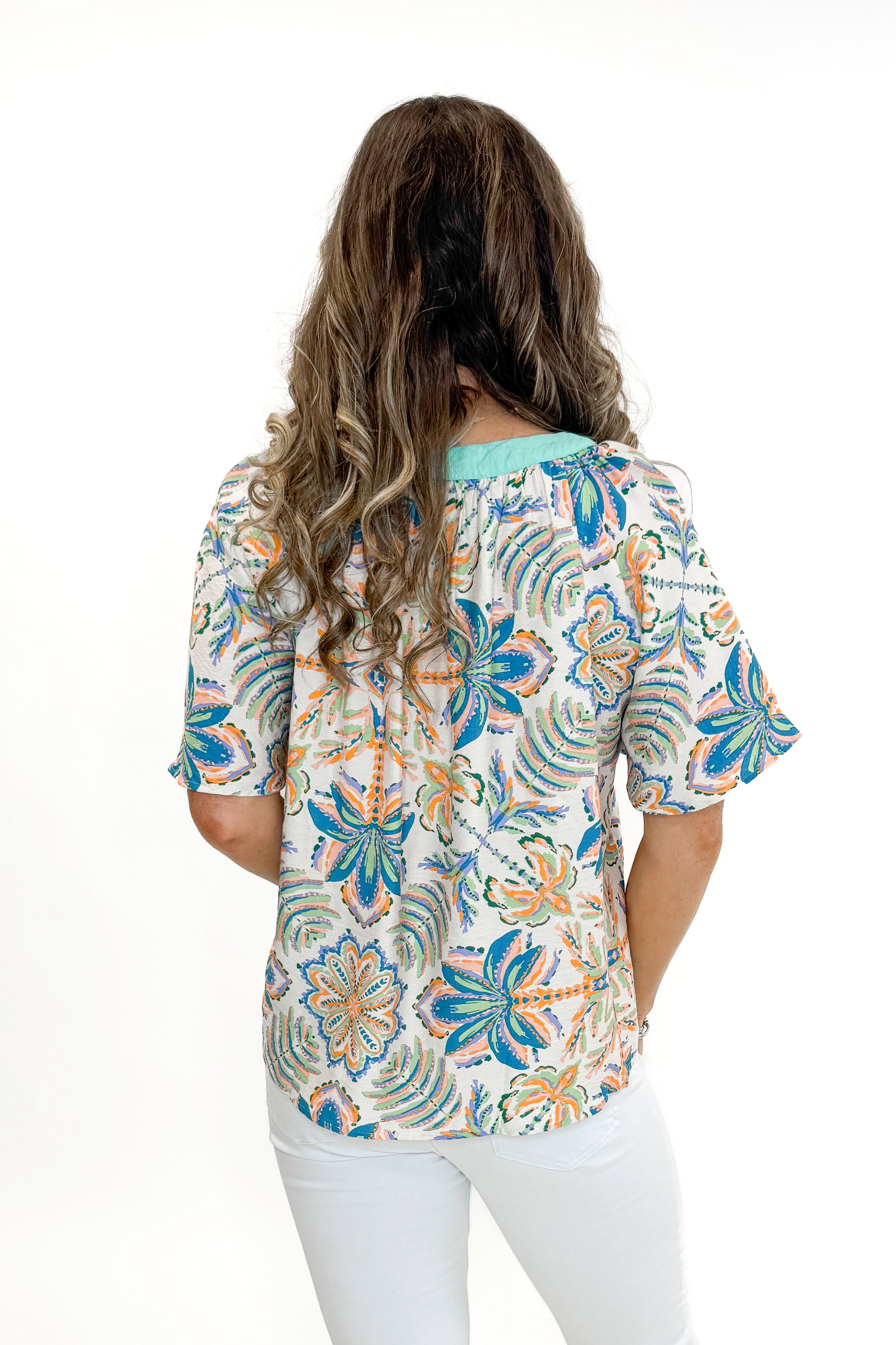 Back view of woman wearing Mint &amp; Multi Tropical Printed Top with jeans against white studio background.