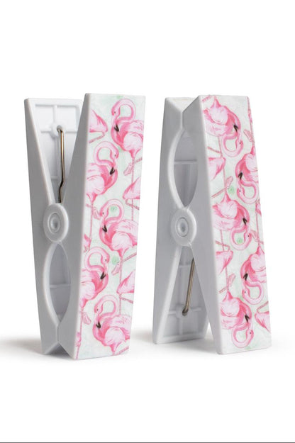 Two white clothespins with pink floral patterns on a white background