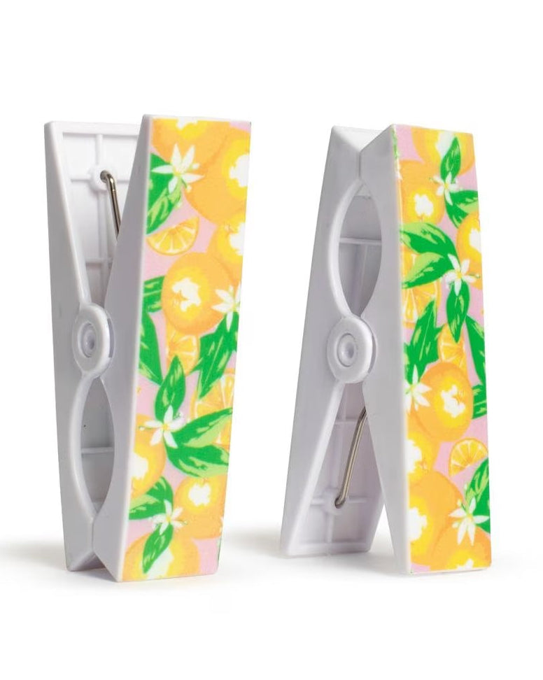 Two beach towel clips with floral patterns on a white background