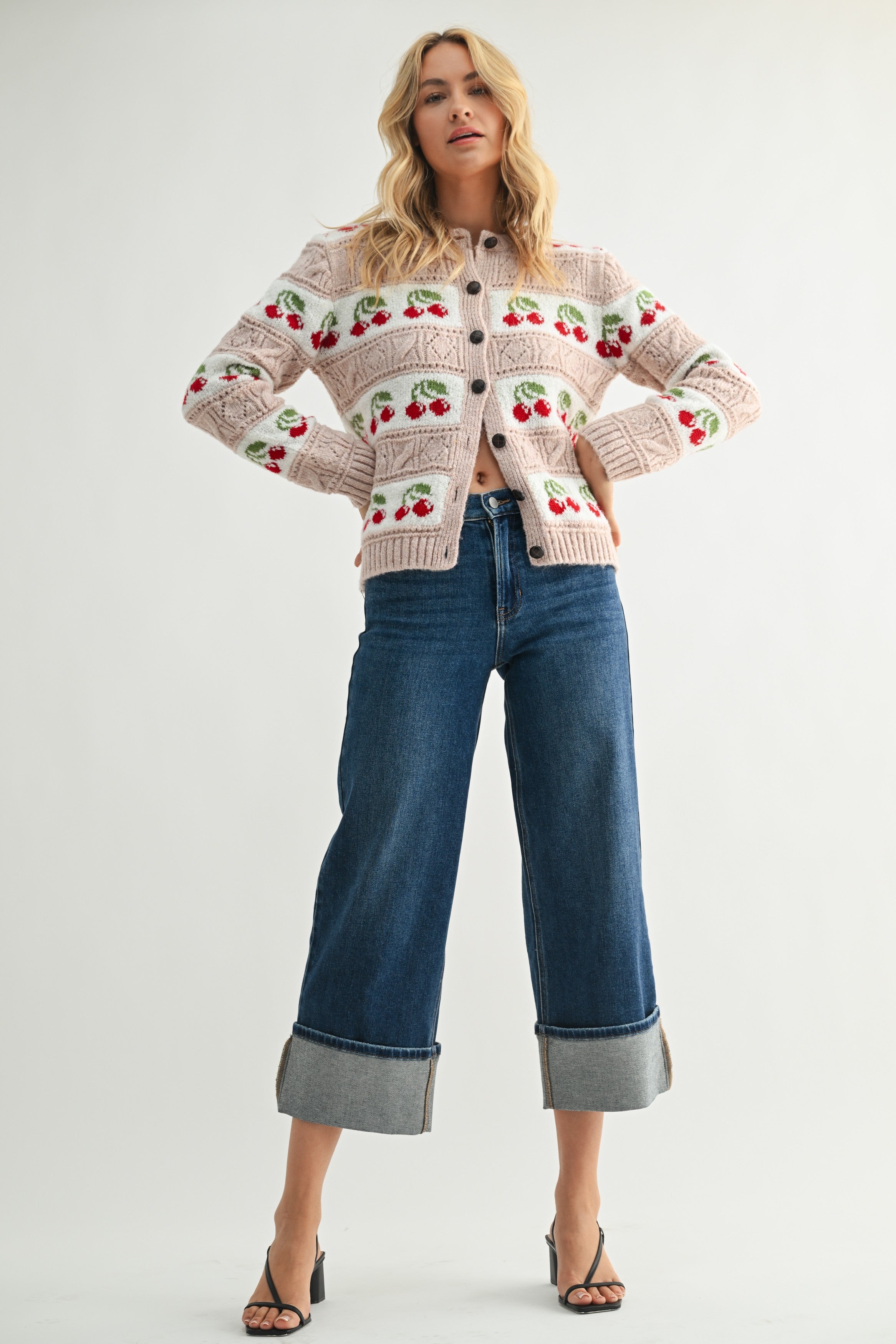 Woman wearing a patterned sweater and jeans on a white background