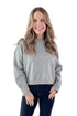 Front view of woman wearing Light Grey Crewneck Sweater with Ruched Sleeve with jeans against white studio background.