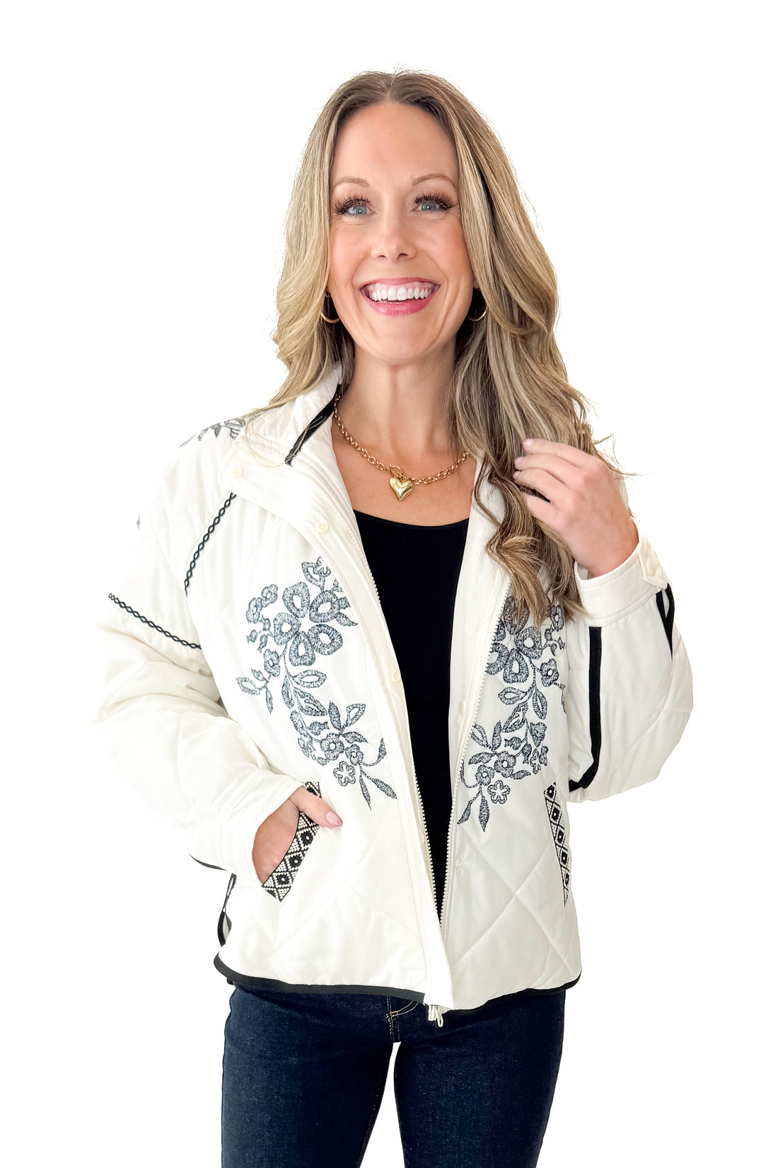 Front view of woman wearing Cream &amp; Navy Embroidery Print Puffer Jacket with jeans against white studio background.