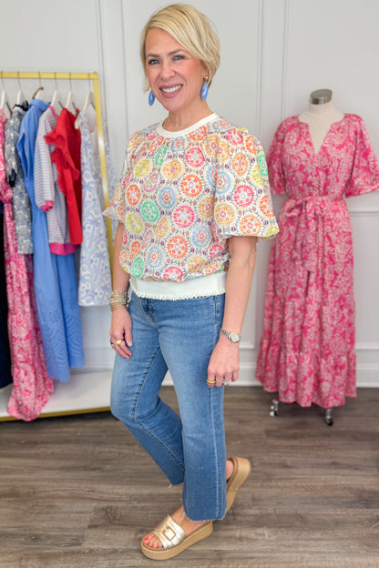 Side view of woman wearing Multi Circle &amp; Floral Print Top with jeans and sandals.