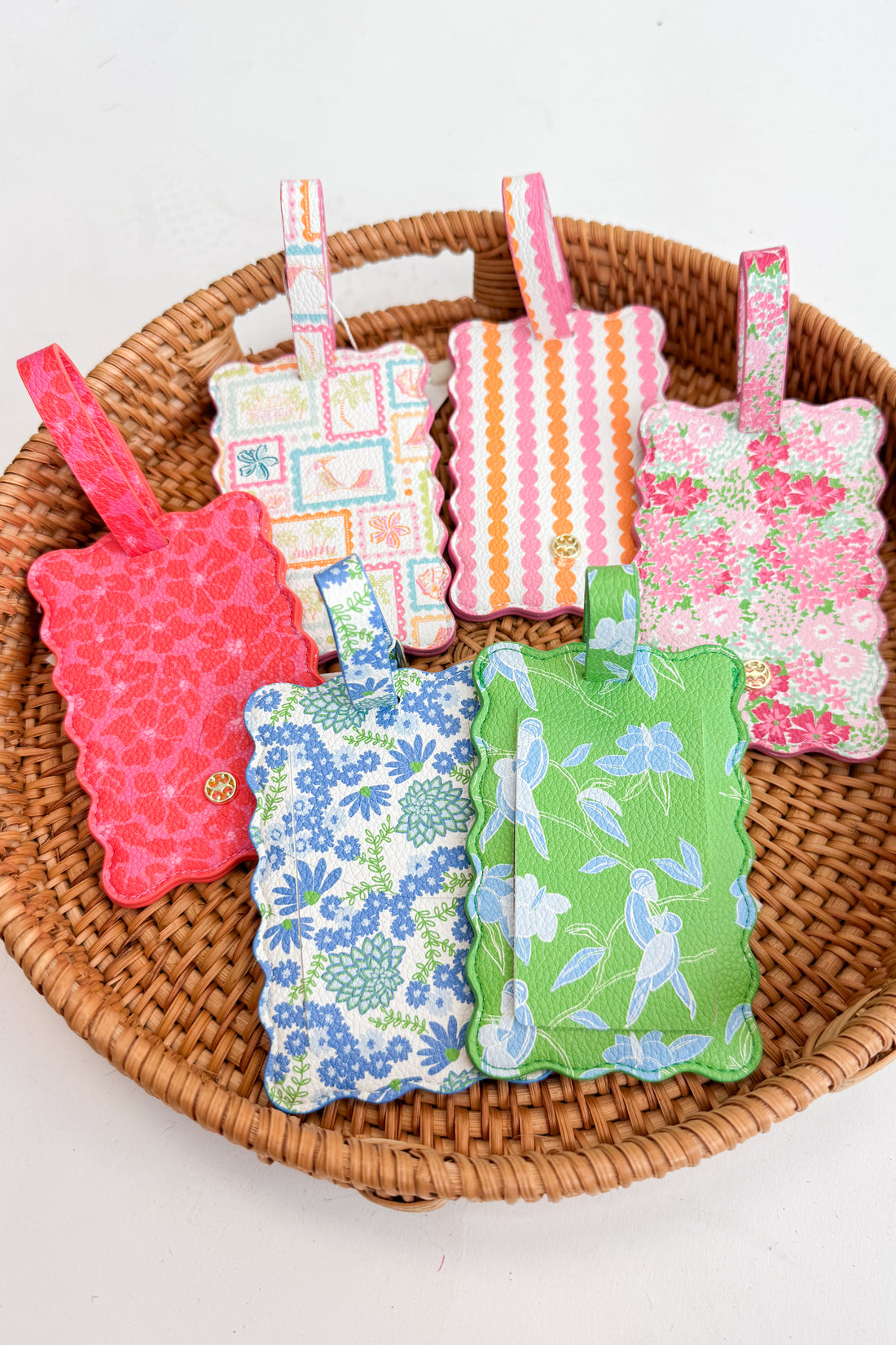 Colorful fabric luggage tags on a woven basket with a white background
