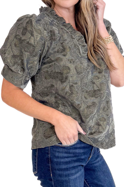 Woman wearing a patterned blouse and jeans on a white background