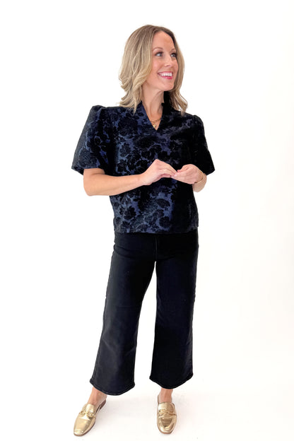 Front view of woman wearing Navy Floral Velvet Jacquard Top with jeans against white studio background.
