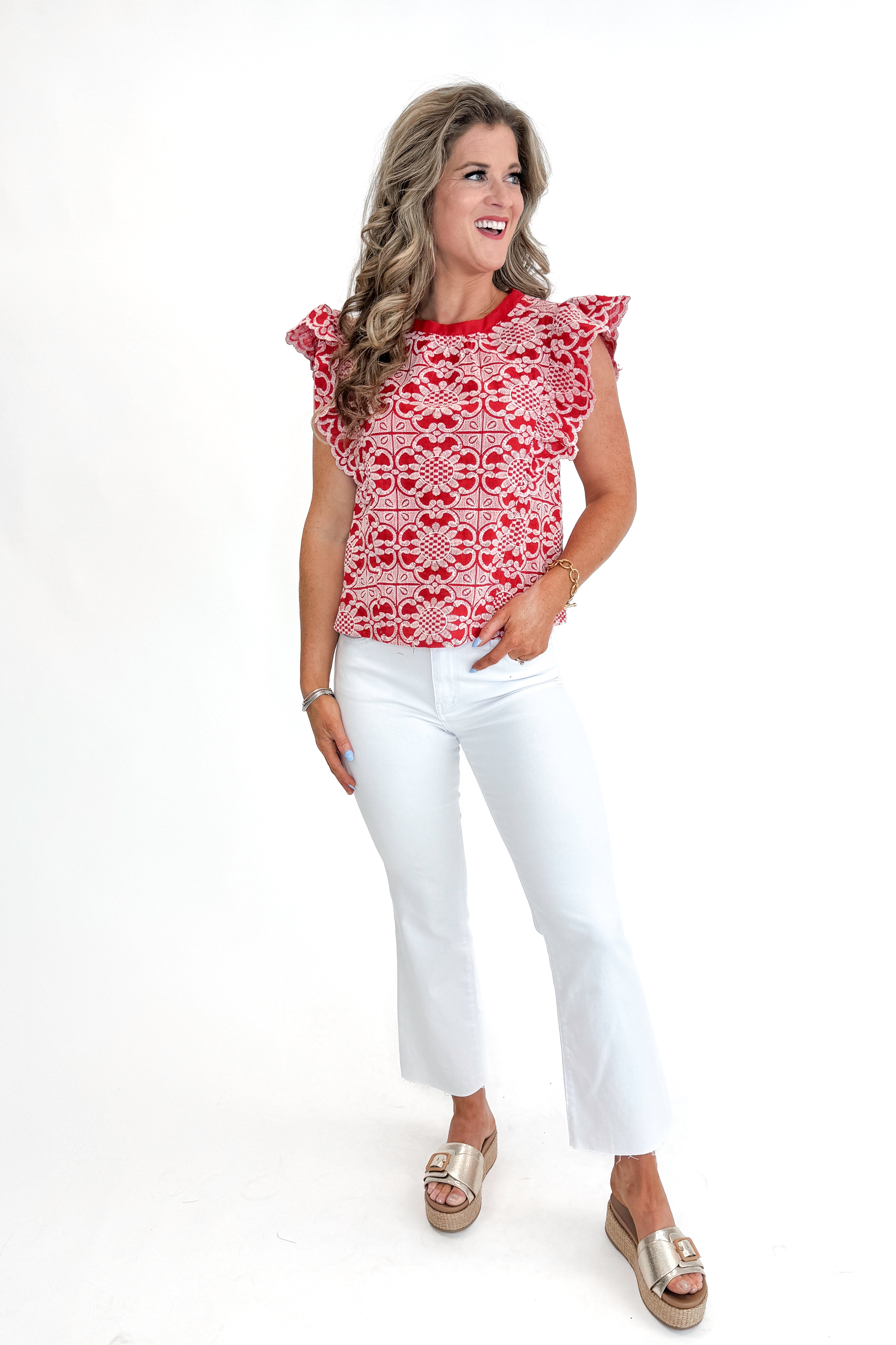 Front view of woman wearing Red Floral Embroidered Top with jeans against white studio background.