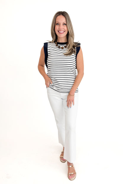 Front view of woman wearing White &amp; Navy Striped Sleeveless Top with white jeans against white studio background.