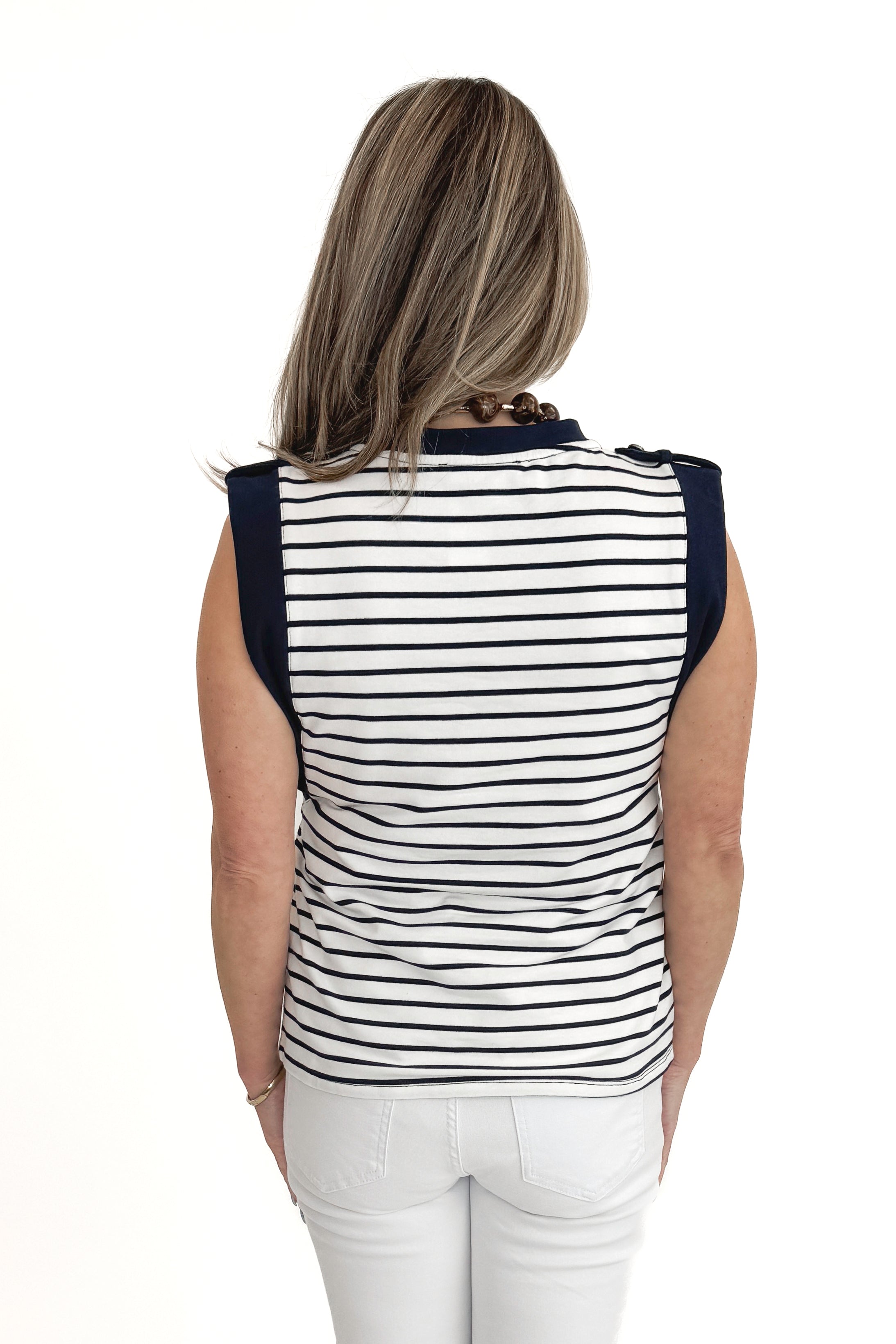Back view of woman wearing White &amp; Navy Striped Sleeveless Top with white jeans against white studio background.