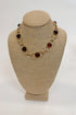 Necklace with amber-colored beads on a beige mannequin bust against a white background