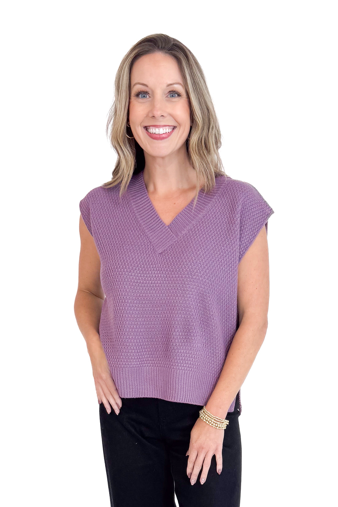 Woman wearing a purple sleeveless top against a white background