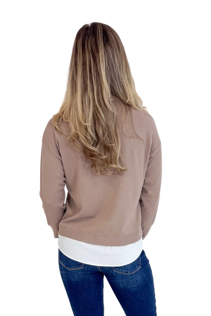 Person wearing a brown jacket, white shirt, and blue jeans on a white background