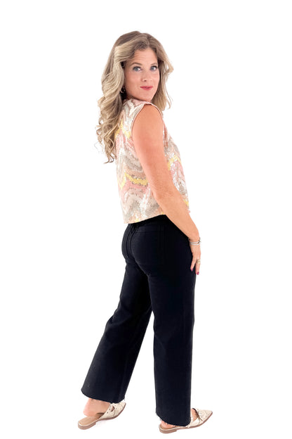 Side view of woman wearing Blush &amp; Multi Sequin Tank Top with jeans against white studio background.