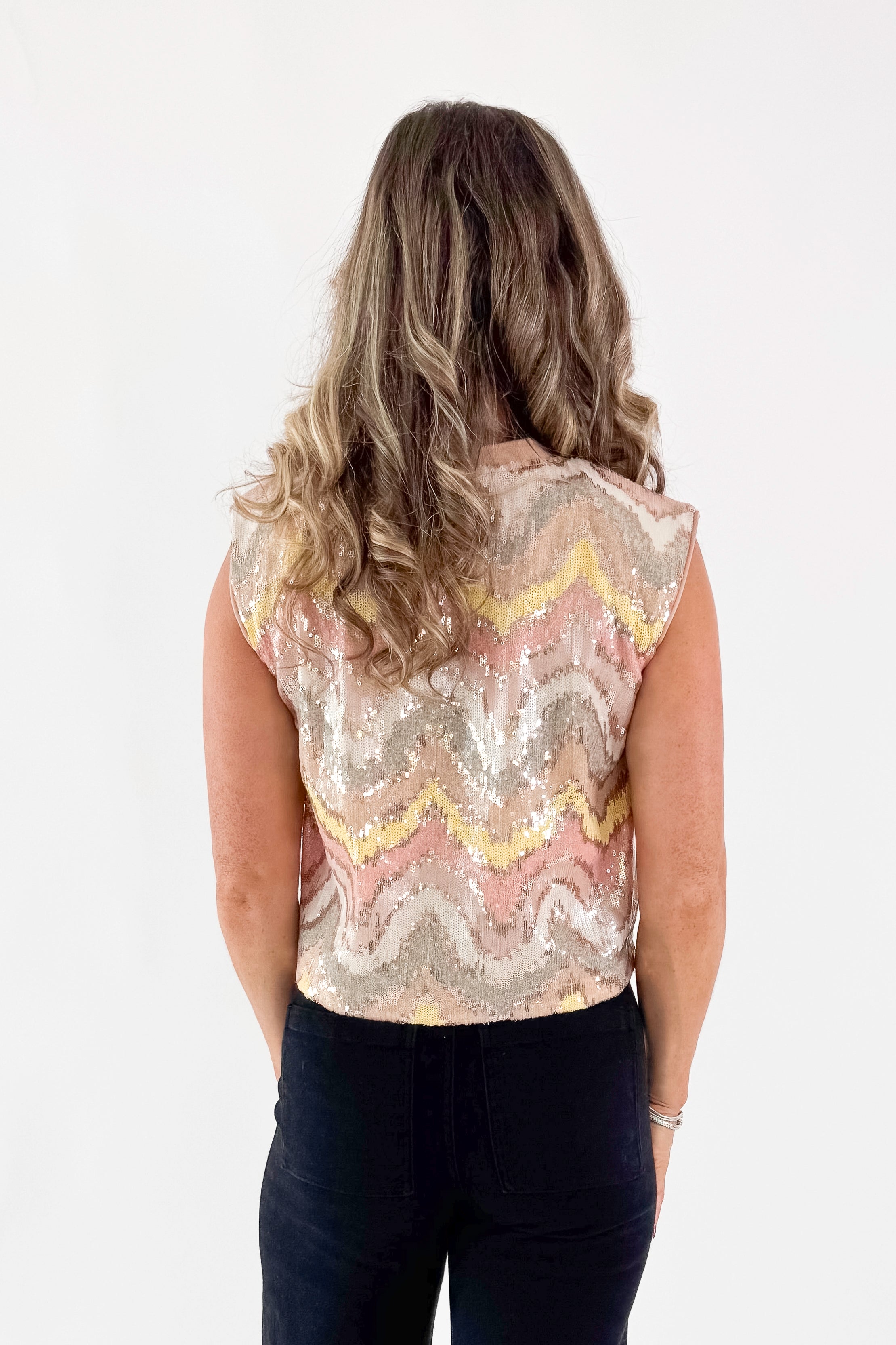 Back view of woman wearing Blush &amp; Multi Sequin Tank Top with jeans against white studio background.