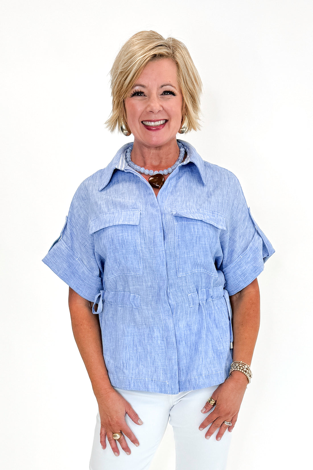 Front view of woman wearing Chambray Cinched Waist Top by Skies Are Blue against white studio background.