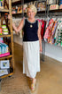 Front view of woman wearing Navy With White Lining Sweater Tank by Skies Are Blue with skirt at Swagger boutique.