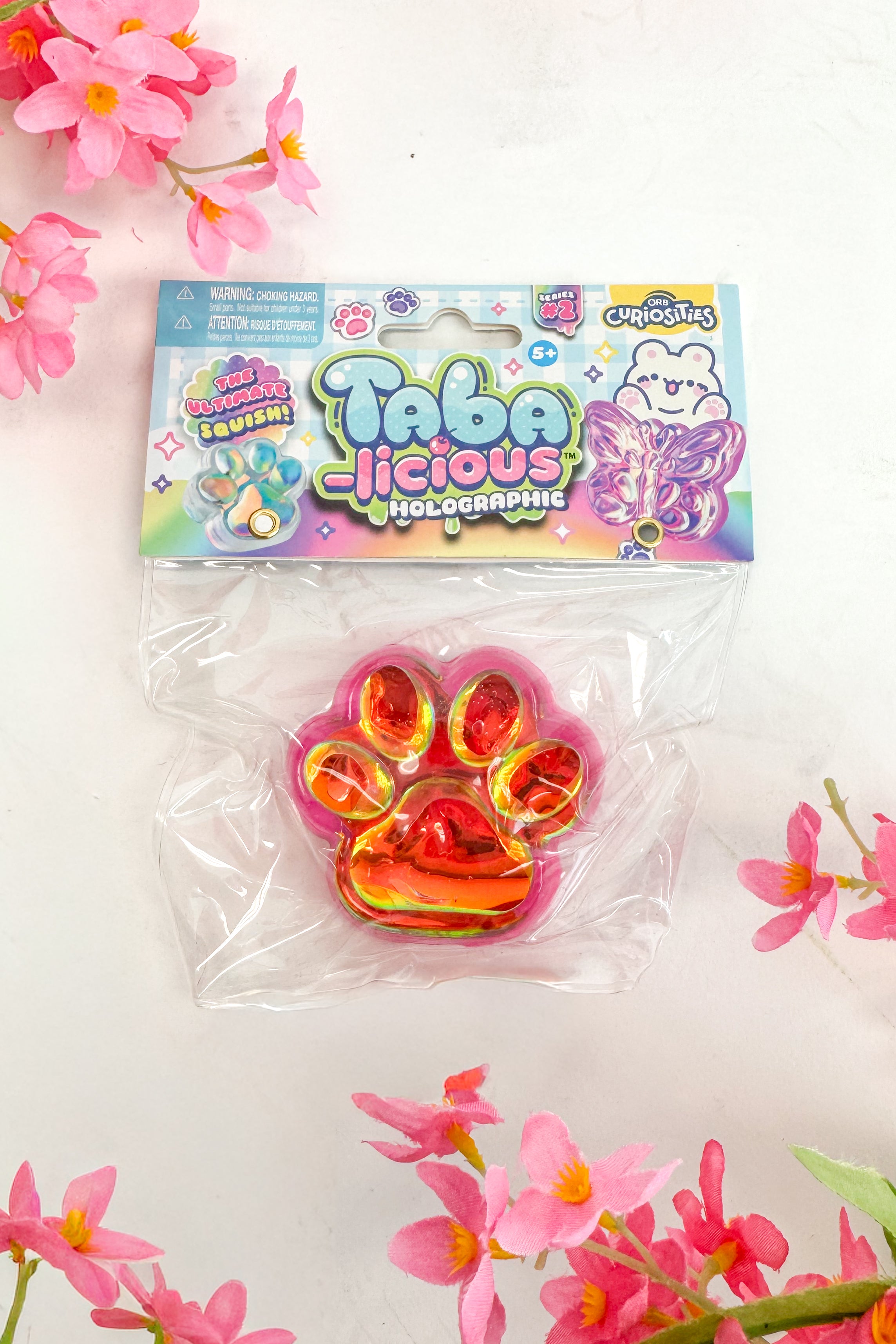 Packaged toy with colorful design on a white background with pink flowers
