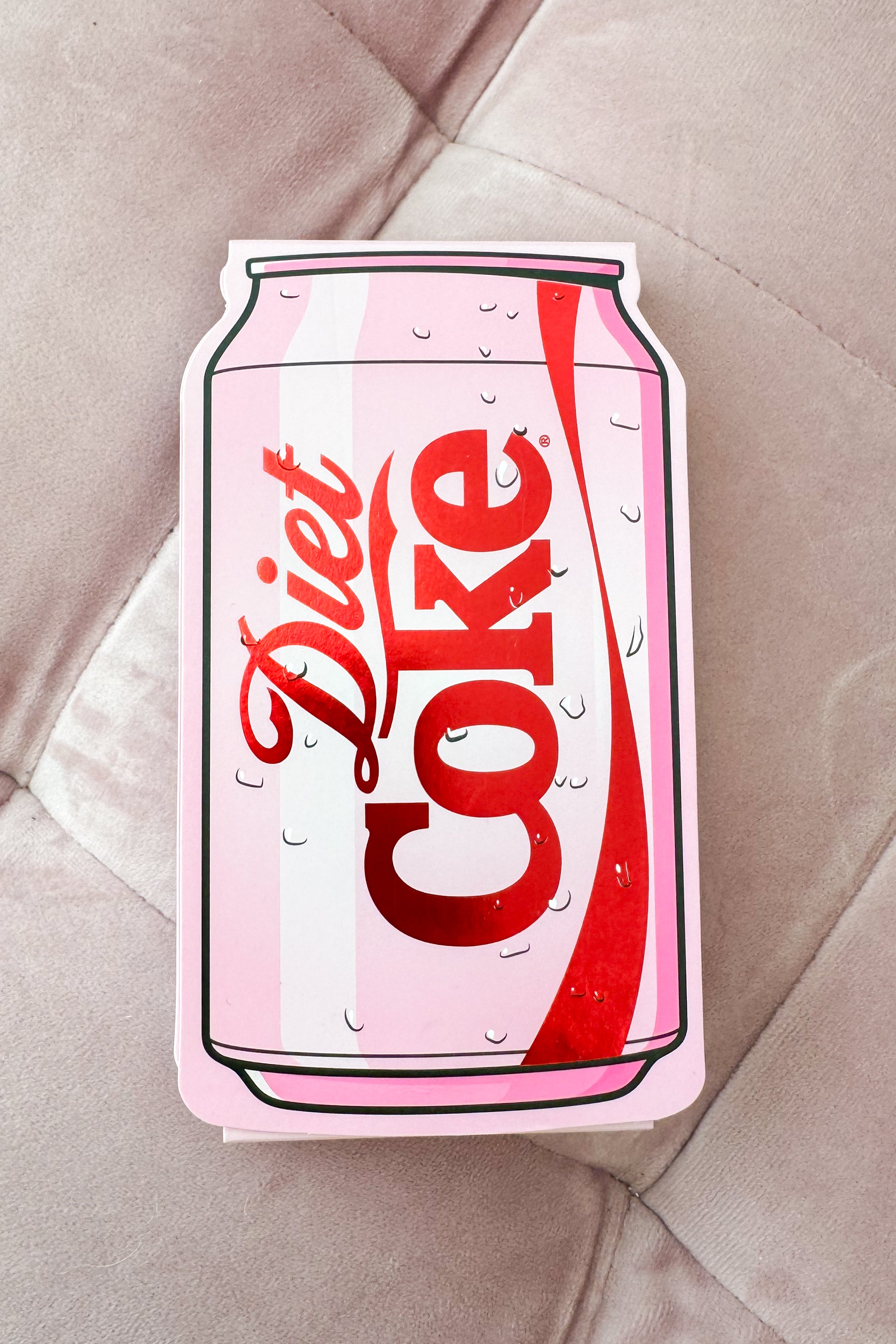 Diet Coke pocket notepad on a textured beige surface