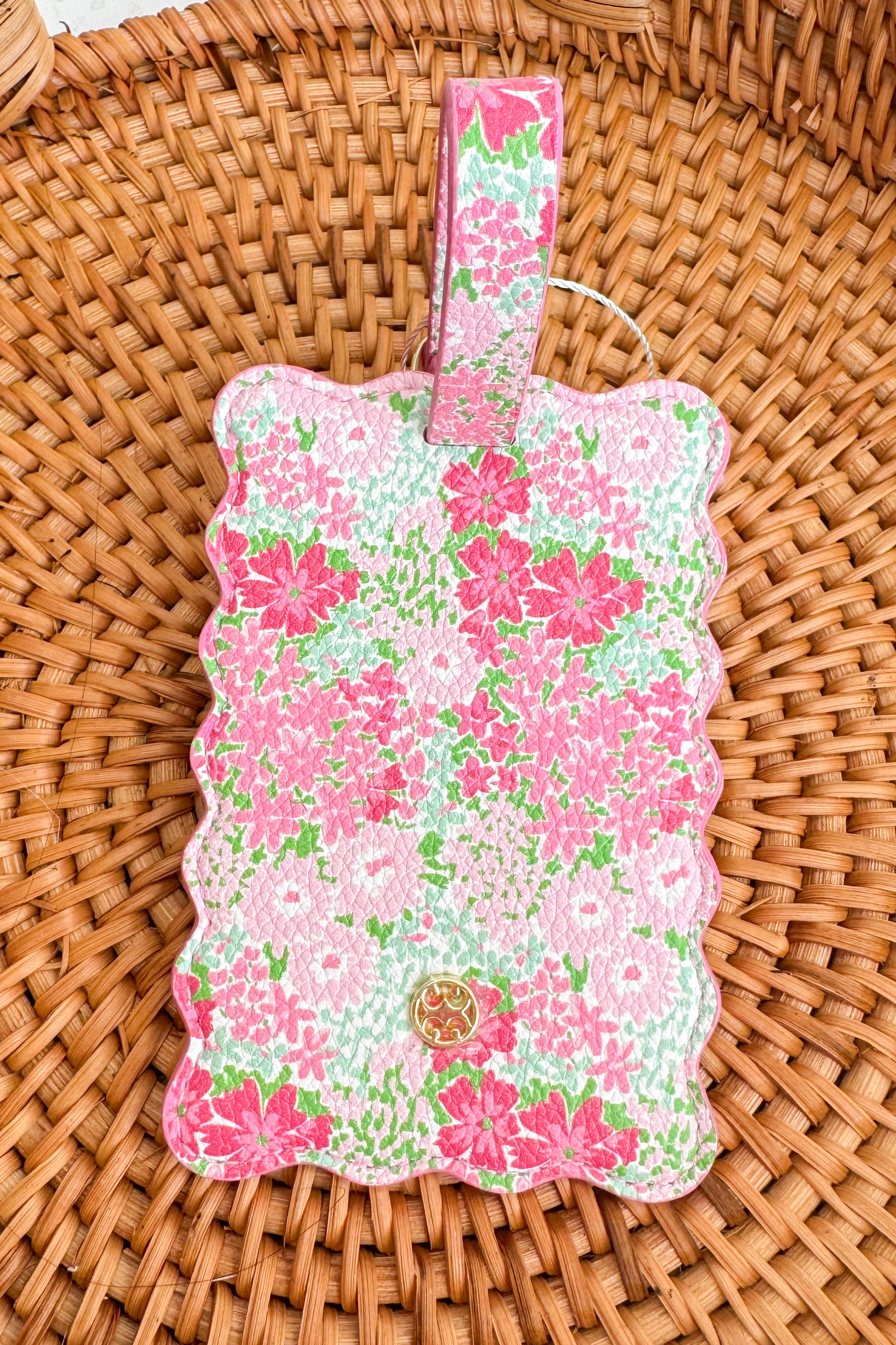 Floral-patterned luggage tag on a woven surface