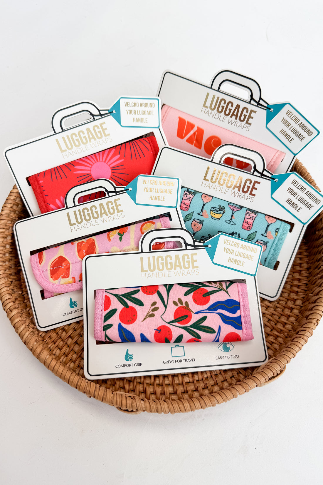 Colorful luggage tags with floral and abstract designs on a woven basket.