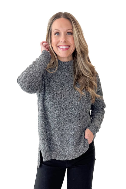 Front view of woman wearing Black &amp; Cream Marled Mock Neck Sweater with jeans against white studio background.