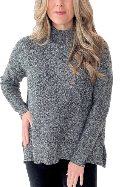 Front detail view of woman wearing Black &amp; Cream Marled Mock Neck Sweater with jeans against white studio background.