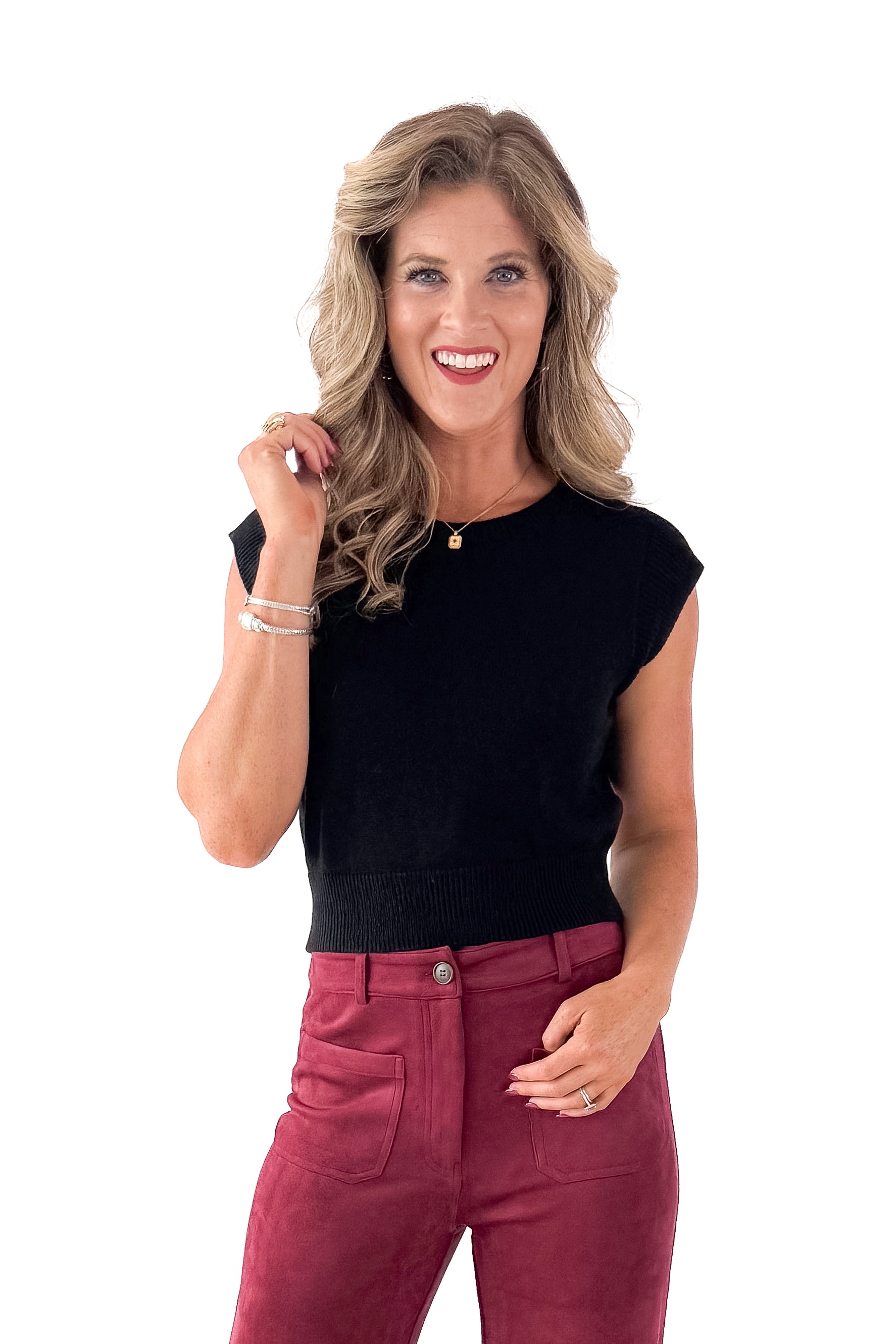 Front view of woman wearing Black Cap Sleeve Sweater with pants against white studio background.