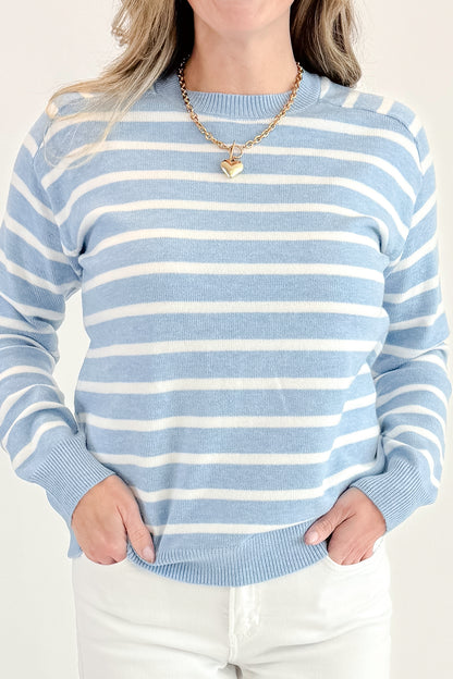 Fron detail view of woman wearing Light Blue Striped Sweater with jeans against a white background.